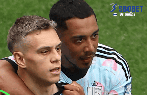 Two soccer players in light blue jerseys embrace on a green field, SBOBET branding visible in the top-right corner.